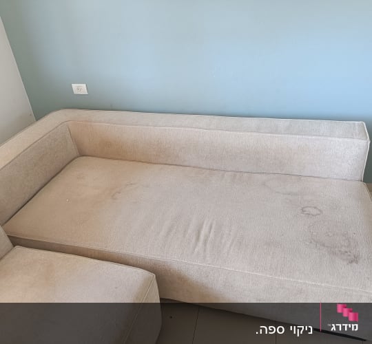 ספה עם כתמים על רקע קיר כחול